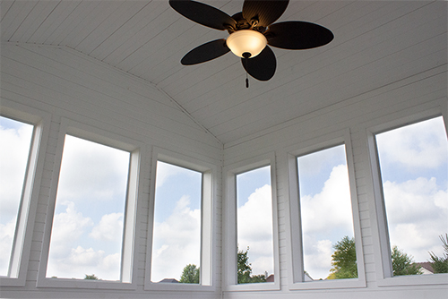 Inside of sunroom with painted white walls and ceiling fan, built in Chicago, IL
